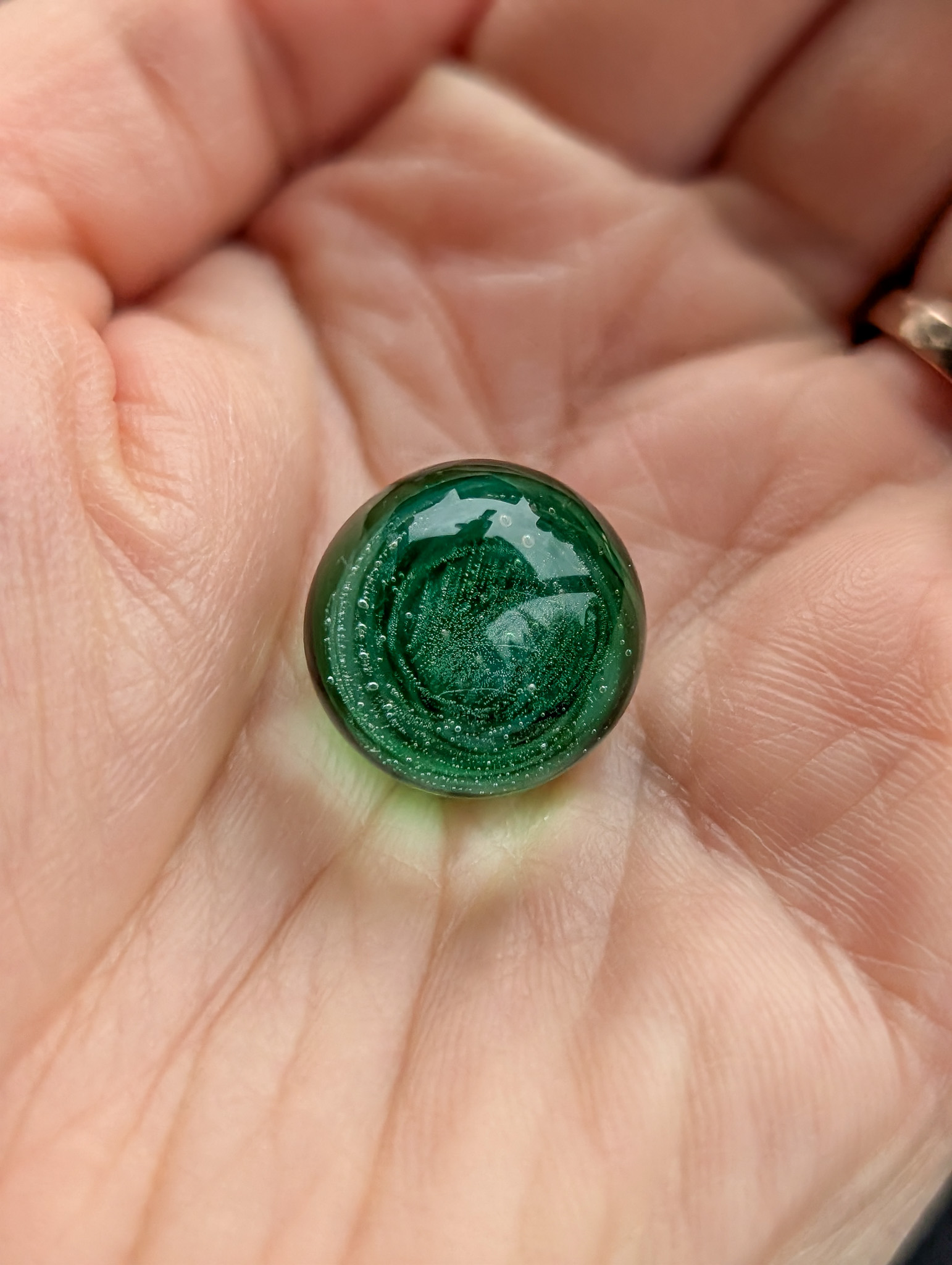 Four handmade glass marbles on dark wood