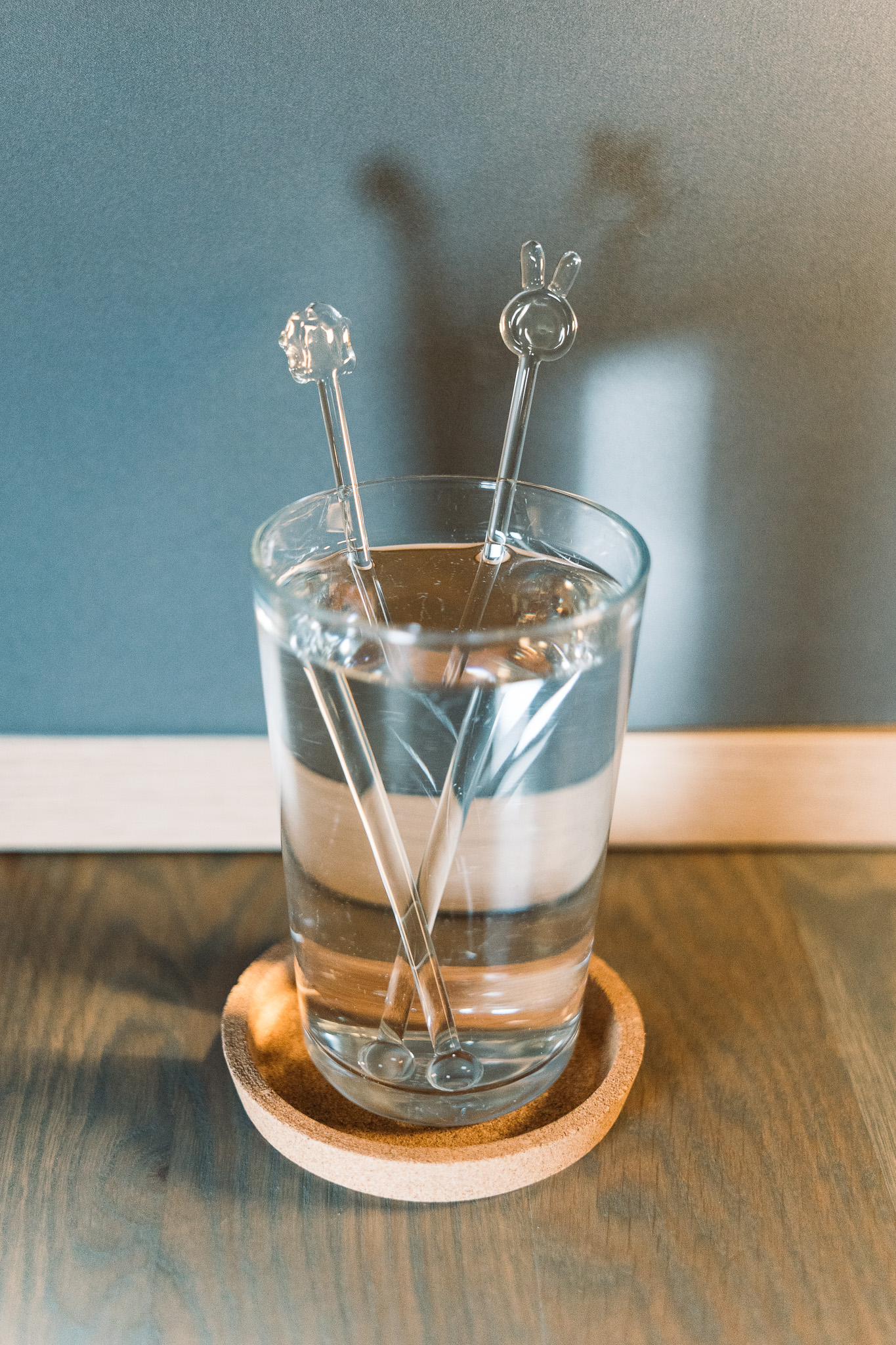 Handmade glass stir rods resting in a drink glass
