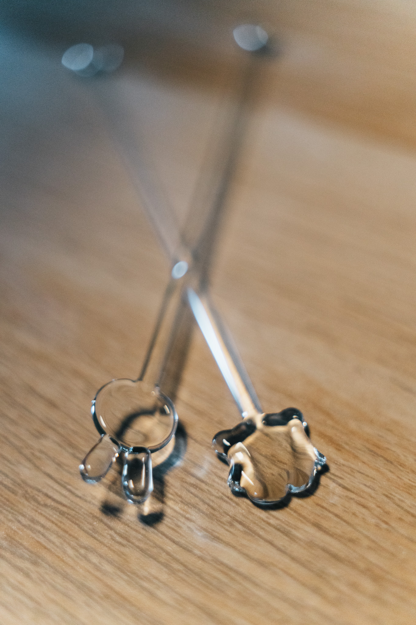 Close view of glass stir rod tops on a wood surface